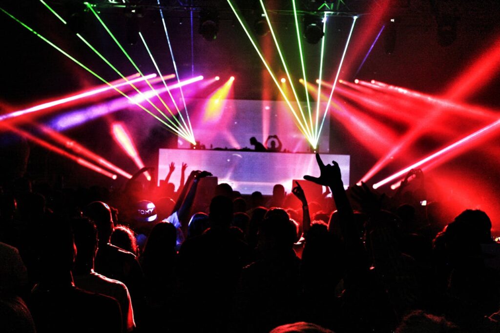 pexels-photo-2114365 Energetic nightclub scene with laser lights and a lively crowd dancing to EDM music.